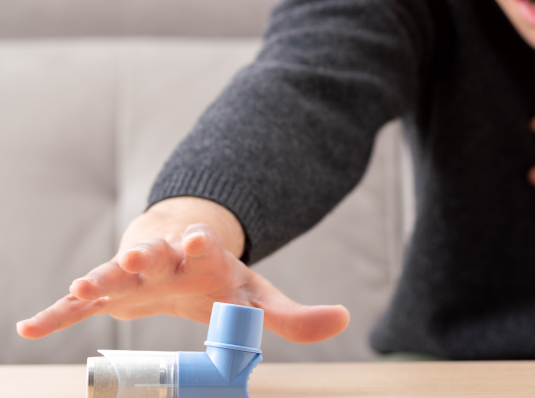 man having an asthma attack reaching for inhaler